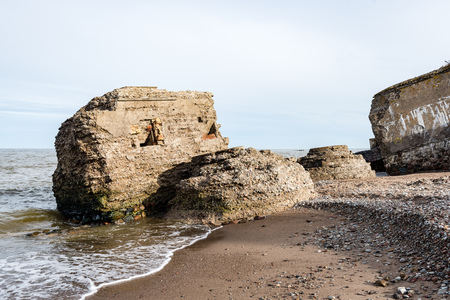 old war fort ruins on the beach with high waves in sunset. Liepaja, Latviaの写真素材