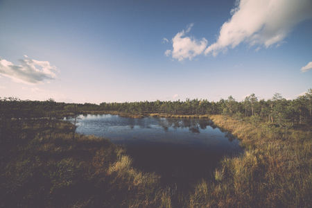 Autumn lake with reflections of trees and clouds - retro, vintage style lookの写真素材