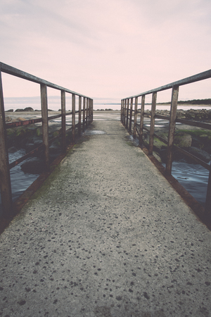 old bridge with rusty metal rails near sea port - retro, vintage style lookの写真素材