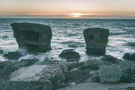old war fort ruins on the beach with high waves in sunset. Liepaja, Latvia - vintage green lookの写真素材