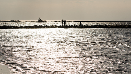 anonymous person walking on a sand at windy beach, leaving marks in sand. Riga, Latviaの写真素材