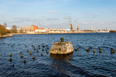dramatic sunrise over the calm river in spring with port industrials operating in background. Daugava, Latviaのeditorial素材