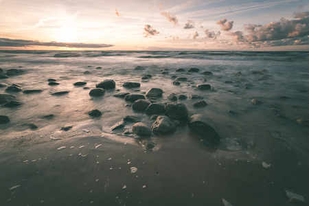 View of a rocky coast beach in the morning. Long exposure shot. Latvia - vintage effect