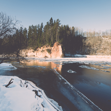 frozen river in winter with sandstone cliffs and ice blocks. Gauja National Park. Latvia. - retro...