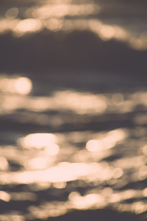 out of focus blur background with sea water in sunset light - retro vintage film effectの写真素材