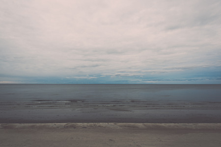 White clouds on the blue sky over country beach - retro vintage looking effectの写真素材