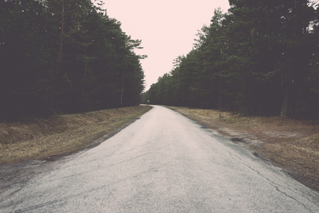 empty country road in spring with perspective and shadows - retro vintage film effectの写真素材