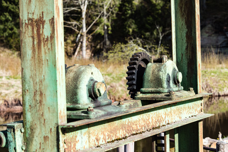Part of the old mechanism with metal gears sprockets chain and other parts covered with rust.