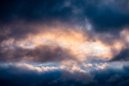 dramatic red and black clouds in sunset over city rooftops