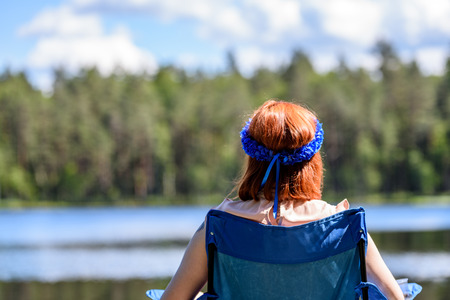 young woman enjoying nature on boardwalk in the lake with water lillies and cloud reflectionsの写真素材