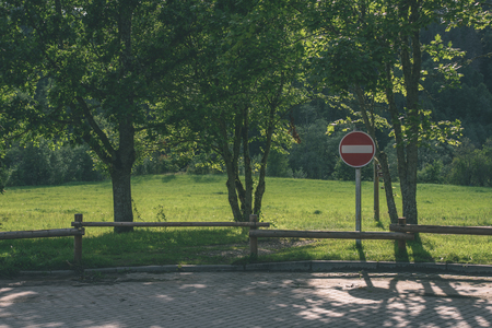 old wooden fence in  beautiful park in autumn in colorful morning  with stop sign - vintage old lookの写真素材