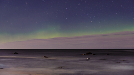 intense northern lights aurora borealis over beach in Latviaの写真素材