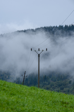 panoramic view of misty forest. far horizon. mountain area in slovakia with electricity polesの写真素材