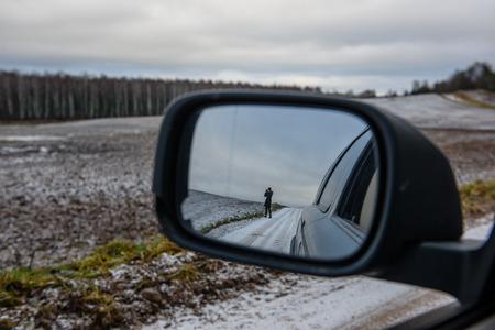 natural landscape reflection in cars mirror. autumn colors. road ahead.の写真素材
