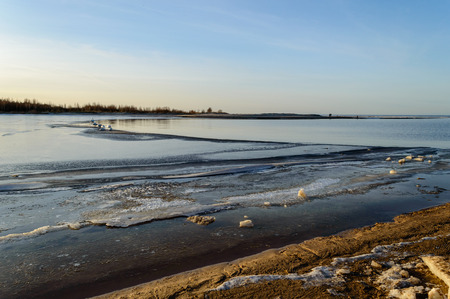 frozen beach in cold winters day with colorful sky and iceの写真素材