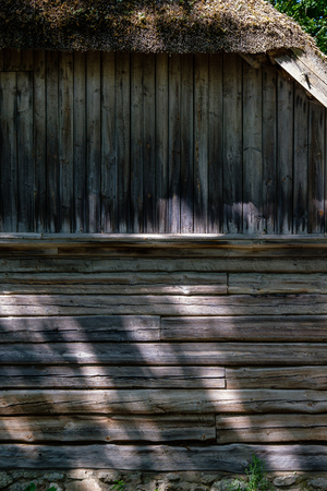 Abandoned ruins of old wooden building in latvia countryside in summer with foliageの写真素材