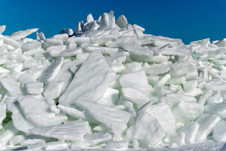 frozen lake covered with stack of ice floes and blue sky. latvia, winterの写真素材