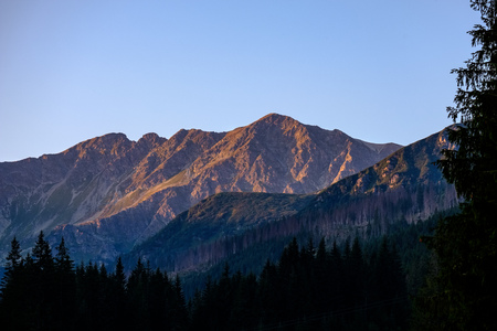 morning light rising over the hill tops and forests in the mountains Tatra in Slovakia. first rays...