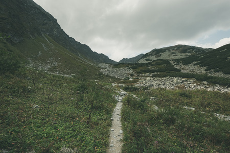 hiking trail in tatra mountains in Slovakia. mounatin view in late summer before autumn, clear sky with some clouds - vintage retro lookの写真素材