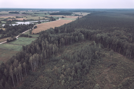drone image. aerial view of rural area with fields and forests under dramatic storm clouds forming. summer day in latvia - vintage retro lookの写真素材