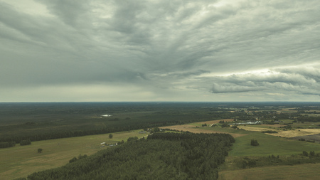 drone image. aerial view of rural area with fields and forests under dramatic storm clouds forming. summer day in latvia - vintage retro lookの写真素材