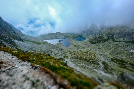 peak of Rysy mountain covered in mist. autumn ascent on rocky hiking trails. Border of Slovakia and...