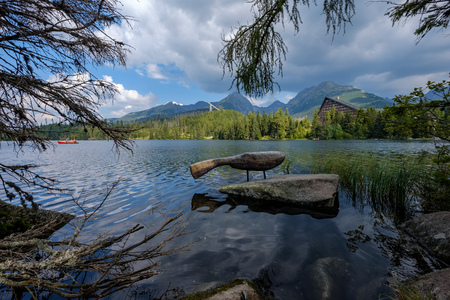 autumn nature reflection in lake of Strbske Pleso in Slovakia surrounded by trees and mountainsの写真素材