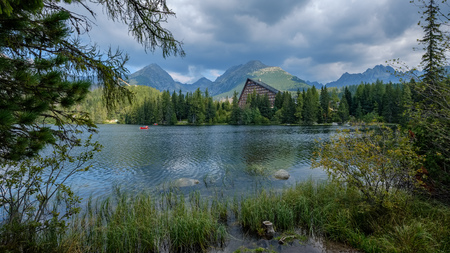 autumn nature reflection in lake of Strbske Pleso in Slovakia surrounded by trees and mountainsの写真素材