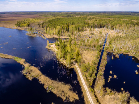 drone image. aerial view of rural area with fields and forests and water reflections in river in...