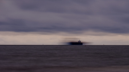 long exposure sea beach with rocks and washed out waves of water. textured abstract imageの写真素材