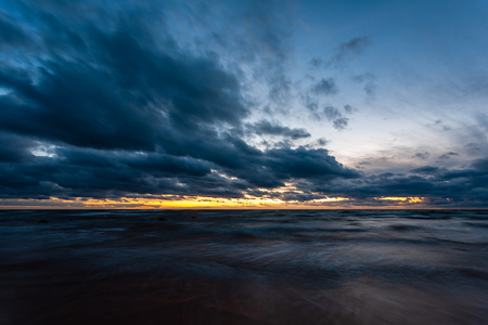 long exposure sea beach with rocks and washed out waves of water. textured abstract imageの写真素材
