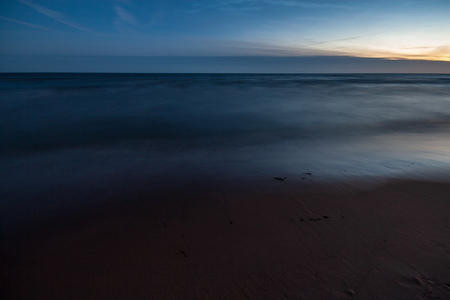 long exposure sea beach with rocks and washed out waves of water. textured abstract imageの写真素材