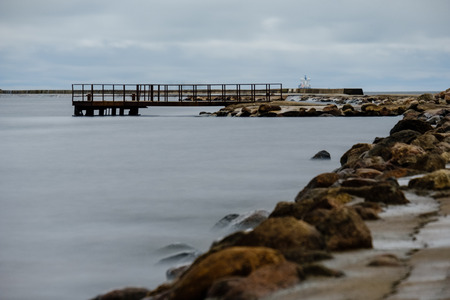 long exposure sea beach with rocks and washed out waves of water. textured abstract imageの写真素材