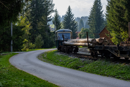 ancient log wood railway and train on the tracks. tourist attraction train in slovakiaの写真素材