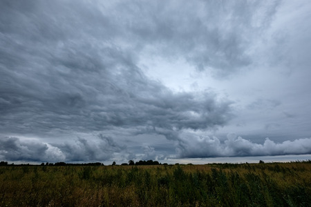 storm clouds forming over the countryside and fields with roadsの写真素材