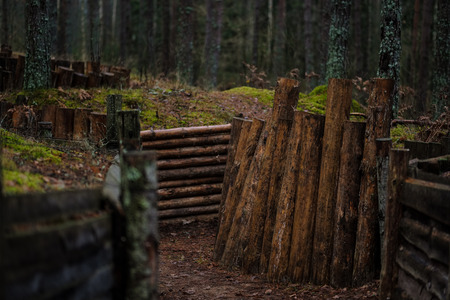 old wooden trenshes in Latvia with barbed wire and guard posts. reconstruction of first world war. Lozmetejkalns. dark forest eveningの写真素材