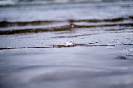 storm clouds over sea. small waves on clean white sand beach. shallow depth of fieldの写真素材