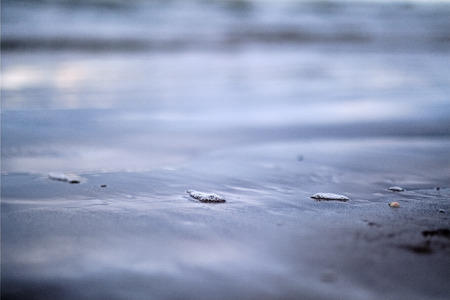 storm clouds over sea. small waves on clean white sand beach. shallow depth of fieldの写真素材