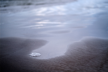 storm clouds over sea. small waves on clean white sand beach. shallow depth of fieldの写真素材