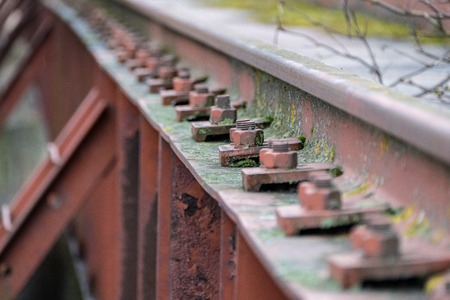 old red metal bridge over water. rusty details and close upsの写真素材