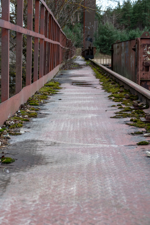 old red metal bridge over water. rusty details and close upsの写真素材