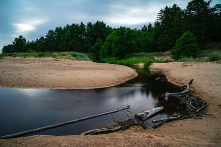 storm clouds forming over clear sea beach with rocks and clear sand. dramatic colorsの写真素材