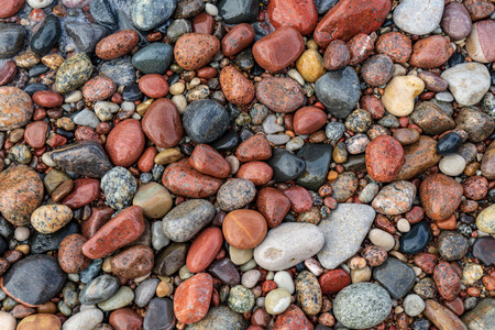 rock covered beach in countryside in Latvia, large rocks in water with calm wind and sunshine
