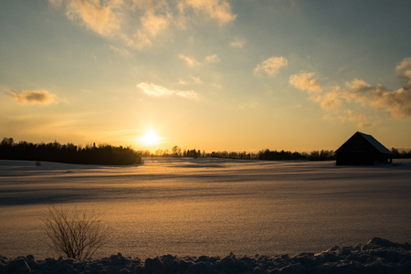 colorful sunset in winter over countryside fields covered in snow. blue skyの写真素材
