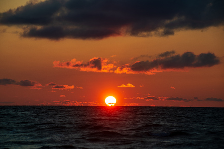 colorful sunset on the sea beach in summer with clean sky and calm water. baltic seaの写真素材