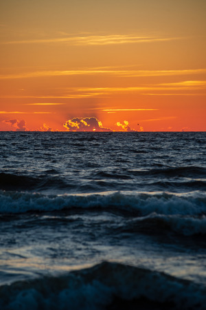 colorful sunset on the sea beach in summer with clean sky and calm water. baltic seaの写真素材