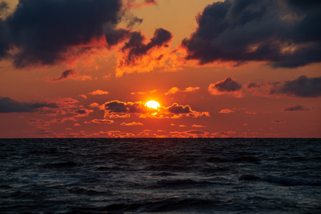 colorful sunset on the sea beach in summer with clean sky and calm water. baltic seaの写真素材