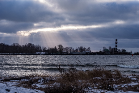 moderate storm in baltic sea near lighthouse in winter with high wavesの写真素材