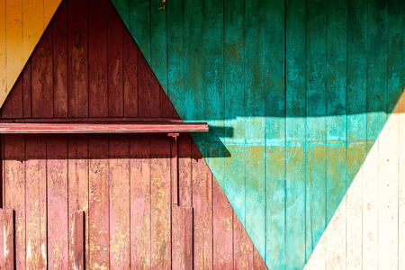 old wwoden plank wall with pealing paint in harsh sunlight. textured backgroundの写真素材