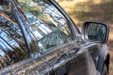very dirty offroad car covered in mud in sunny forestの写真素材